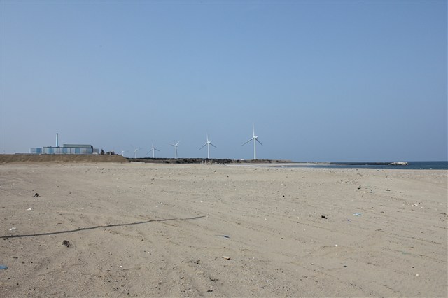 写真：曇り空の砂浜と風車