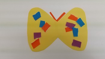 写真：ちぎった各色の折り紙を貼った黄色いチョウチョの色紙