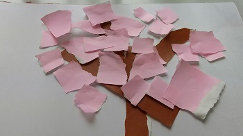 写真：茶色の折り紙を木に見立て、ピンクの折り紙をたくさん貼って作った桜の木