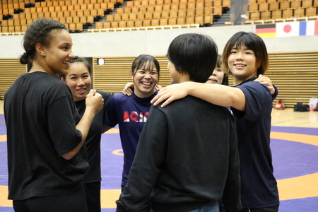 写真：練習の合間に海外の選手と日本の選手が集まり、肩を組みながら笑顔を浮かべる様子