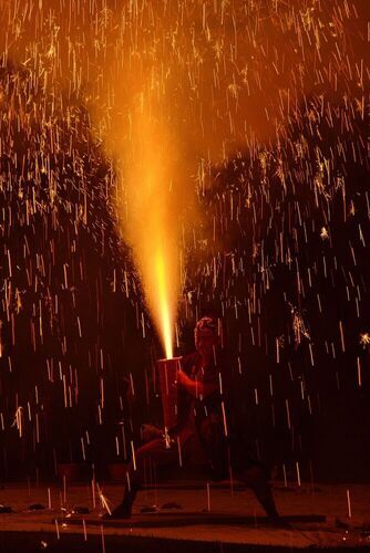 写真：巨大な火柱を上げる手筒花火とそれを御する職人