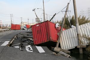 写真：陥没した道路に落ちたコンテナと巻き込まれた複数の電柱