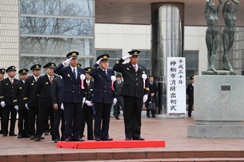 写真：文化センター前で敬礼する石田市長