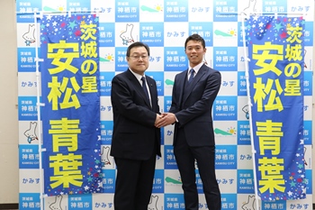 写真：固く握手する安松さんと石田市長