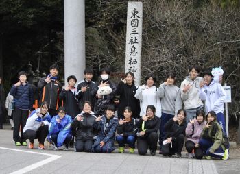 写真:息栖神社の鳥居の前で記念撮影をする陸上クラブの面々
