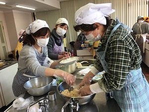 写真：調理室で材料の麹と塩を混ぜる様子