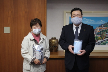 写真：寄付された消毒液とマスクを手に持ち記念撮影