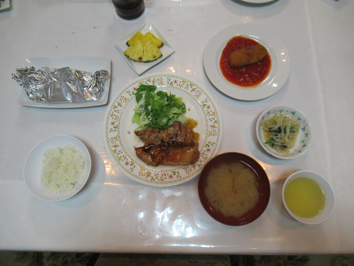 写真:鳥の照り焼き、白米、味噌汁、漬物などの食事