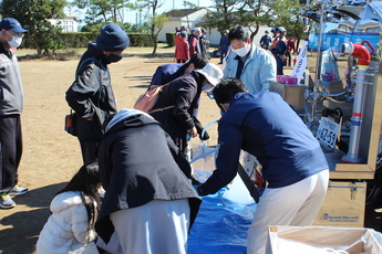 写真:給水場でポリ袋に給水する人々