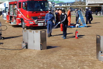 写真：消防士による指導の下、消火器を使う人