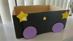 写真：段ボールに紙でできたタイヤと星型を貼り付けた様子