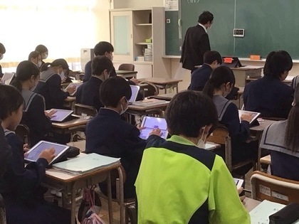 写真：タブレット操作しながら授業を受ける生徒達