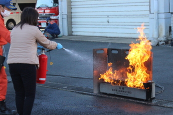 写真：消火器を使って火を消す初期消火講習の様子