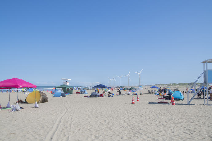 写真：青空と海岸とパラソルと風車