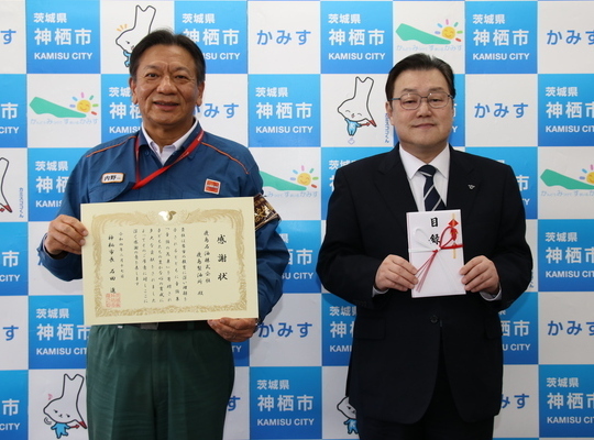 写真：2月17日撮影の訪問者と目録を持つ石田市長