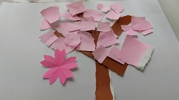 写真：桜の形に切り抜いた折り紙の花と桜の木