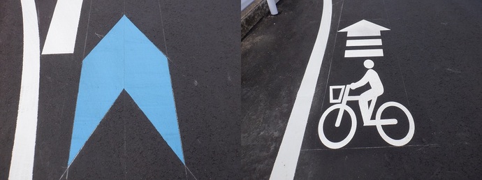 写真：道路に塗装された水色の矢羽根と白色の自転車ピクトグラム