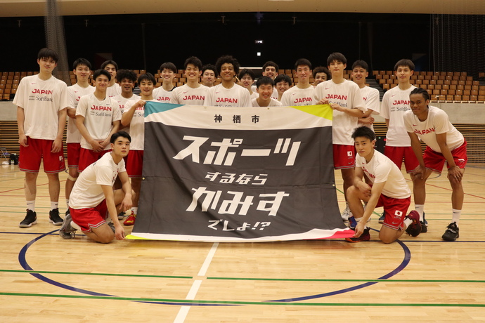 写真：旗とともに、記念撮影をするバスケットボールU22男子日本代表選手