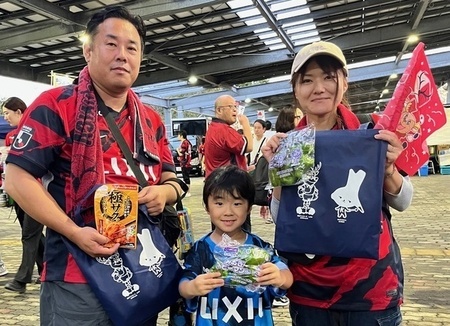 写真:無料配布のピーマンなどを受け取った家族