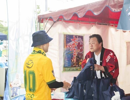写真：石田市長がピーマンを無料配布する様子