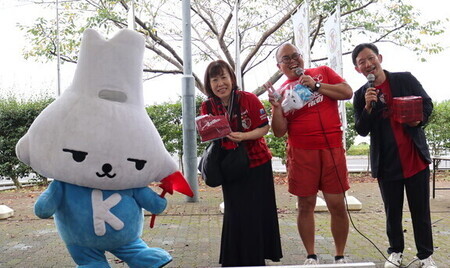 写真:景品が当選し喜ぶ人とオスペンギンとカミスココくん