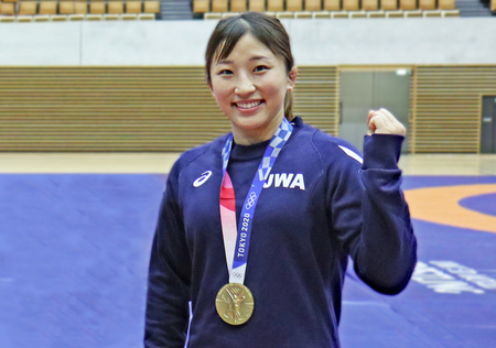 写真：東京オリンピックの金メダルを首からさげ、笑顔でガッツボーズをする須﨑選手