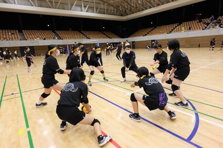 写真：バレーボール講習会でレシーブの受け方を講師から学ぶ生徒たち