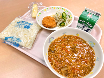 写真：うどん、牛乳、鮭のメンチカツ、もやしときゅうりのサラダ、盛岡風ジャージャーめん、りんご