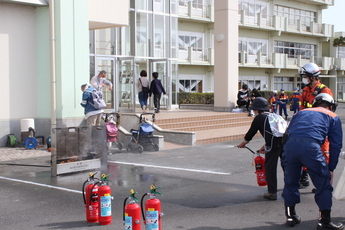 写真:市民が消火器を持って火を消す様子