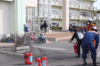 写真：市民が消火器を持って火を消す様子