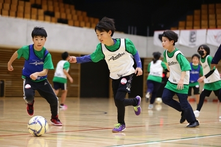 写真：サッカーボールを追いかける参加者たち