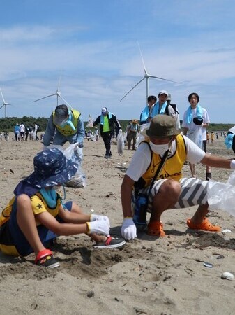 写真：日川浜海岸にてごみ拾いをする親子