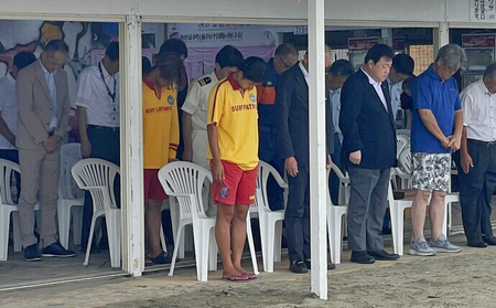 写真:2023年7月14日、海の家にて黙祷する市長