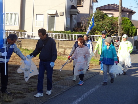 写真：ごみ袋を片手にごみを拾う人達