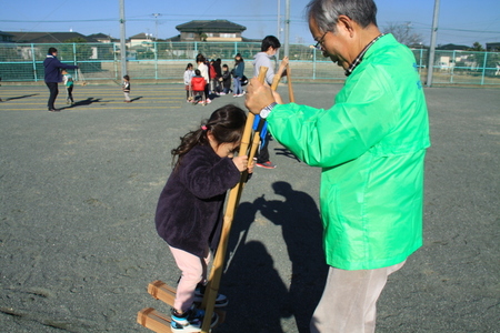 写真：幼い女の子が竹馬で遊ぶ様子