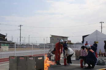 写真：消火器を使い消火する市民