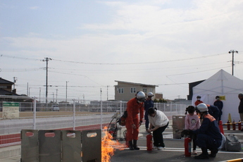 写真:消火器を使い消火する市民