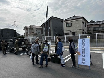 写真:自衛隊車両について説明を受ける市民