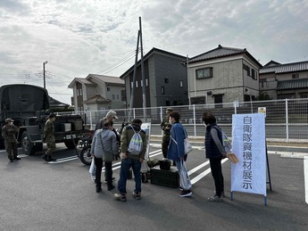 写真：自衛隊車両について説明を受ける市民