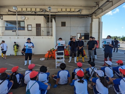 写真：小学生に船曳網漁業の説明する地元漁師