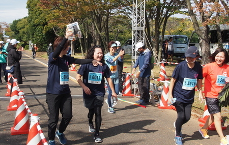 写真：笑顔でゴールにむかう参加者たちとゲストランナーの有森裕子さん