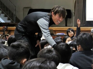 写真：手を挙げる児童に回答を求める安松さん
