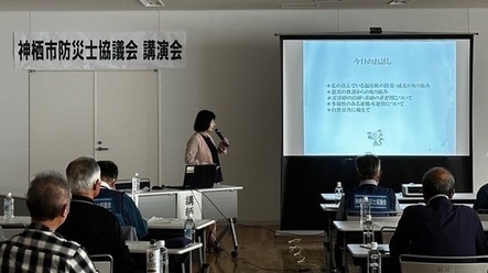 写真：スライド資料を基に講師から説明を受ける参加者