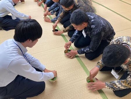 写真：高校生からお茶の点て方を教わる技能実習生達