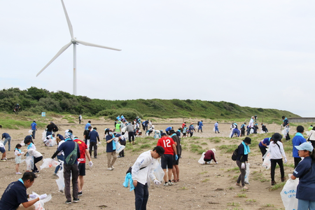 写真：日川浜海岸にてごみ拾いをする参加者