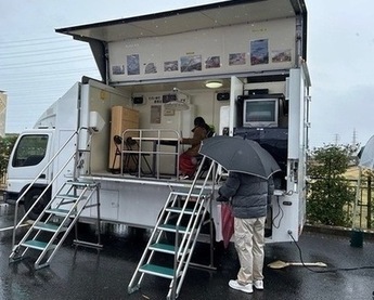 写真：生活空間を再現した起震車に乗車し、地震を体験する参加者