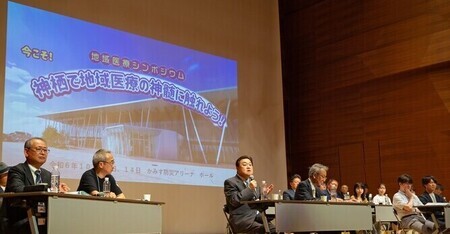 写真：2024年10月13日神栖防災アリーナにて撮影。地域医療シンポジウム参加者に向かって挨拶をする市長