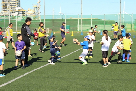 写真：笑顔でサッカーボールに触れる子どもたち