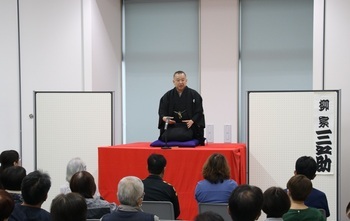 写真：独演中の柳家三之助さんとそれを鑑賞するお客さん