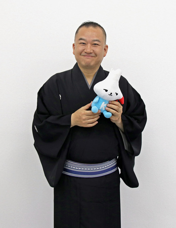 写真：カミスココくんのぬいぐるみを持った神栖市PR大使の柳家三之助さん